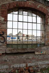 A view from a window of a demolished building, old factory. Weathered wall. Broken window.