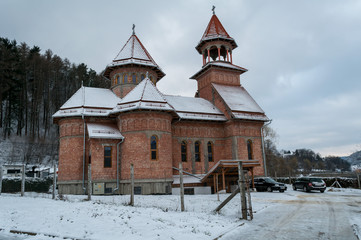 Church made of bricks. Rooftop covered with snow. Winter scene.