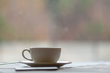 Coffee cup, tea cup sitting on the table. White table cloth.