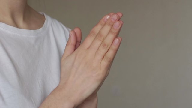 young woman wearing white shirt and hold her hands in pray