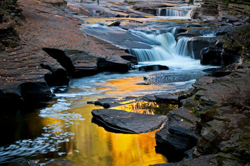 Fall colors reflecting in a calm pool in the Presque Isle River just upstream from where it empties into Lake Superior.