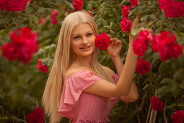 Beautiful blond girl in dress posing in summer park