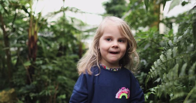 A little girl in a jungle dress runs away from the camera