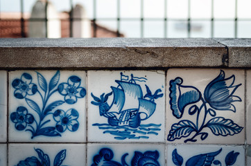 Porguguese caravel ship painted over traditional Azulejos in Lisbon, portugal, where is easy to find hand painted glazed blue and white tiles over the walls of the city