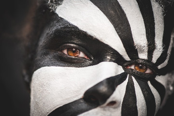 Close Up of female model with black and white abstract make up and piercing hazel brown eyes