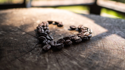 coffee beans on wooden table with sun light. coffee lover lifestyle concept