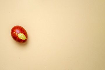 Chicken egg colored with old-fashioned natural method by onion husks isolated on light brown. Topview of brown egg with different natural patterns with copyspace. Traditional Easter and Spring concept