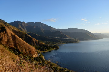 Naklejka premium Hilly landscape with shores of lake in a sunny day