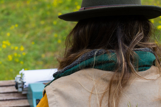 Blonde Scout Girl In Green Vest And Green Hat Typing. Digital Nomad.