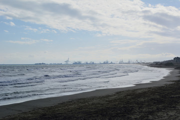 The port cranes seen from the beach.