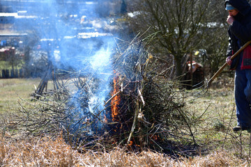 Farmer burns old leaves and branches in the spring
