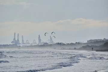 Harbor cranes with giant kites in front