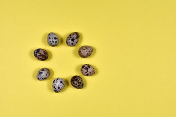Easter eggs laid out in a circle on a yellow background. View from above. The basis for the postcard. Easter concept.