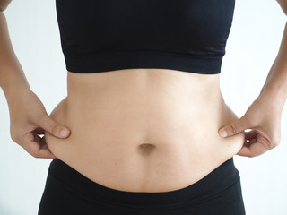 cellulite and belly fat in woman and she grabbing her  waist around hip cause of fatty from weight...