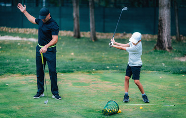 Golf Lesson. Golf Instructor Teaching Young Boy How to Swing