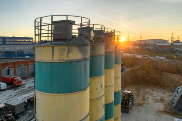 Obraz premium Silos for storage of cement aerial view. Silos are painted in yellow and green stripes.