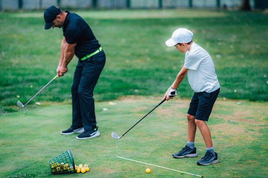 Golf Lessons. A golf Instructor and a boy practicing on a Golf Practice Range