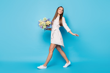 Full size profile photo of pretty lady hold fresh wildflowers bunch walk street enjoy sunny day...