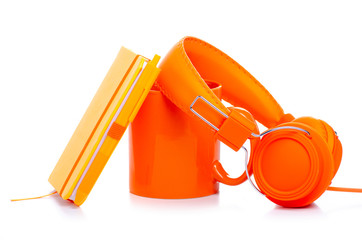 Obraz premium orange cup mug and diary notebook, headphones on white background isolation