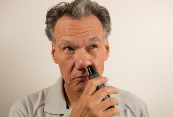 Man Trimming his Nose with a Nose Hair Trimmer