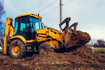 Closeup of a large bucket excavator digging the ground to set the road.