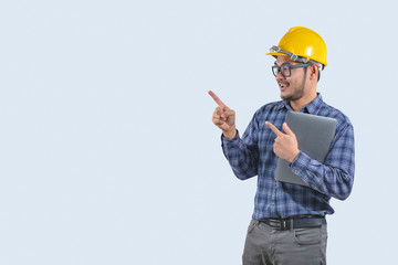 Young computer engineer asian man with laptop and yellow hard hat , Asian man point on empty space