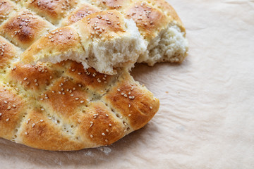 Freshly baked soft flat bread in the style of the Turkish Ramadan Pide on baking paper, selected focus, narrow depth of field