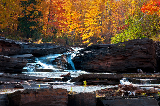 Glowing autumn colors at Bonanza Falls on the Big Iron River, Upper Peninsula, Michigan.