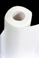 Roll of white soft toilet paper on black background