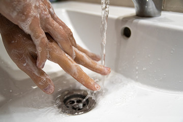 Fototapeta premium Washing hands with soap and water to prevent virus. Coronavirus pandemic protection by cleaning hands frequently.