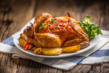 Roasted chicken and american potatoes with chili peppers and herbs
