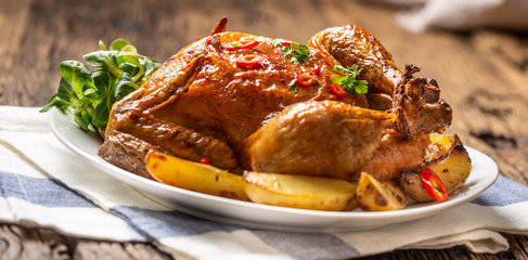 Roasted chicken and american potatoes with chili peppers and herbs
