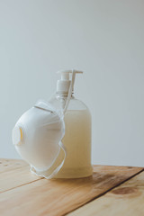 antibacterial and face mask on wooden table