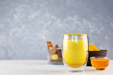 Golden milk and ingredients for preparation: turmeric, honey, ginger root, cinnamon, badian on a...