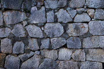 Texture of stone wall made of grey stones
