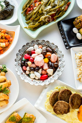 Traditional Turkish dinner table(bayram sofrasi))the End of Ramadan Feast or Sacrifice Feast.Designed feast foods around of copper candy bowl,on the white surface.Top view.