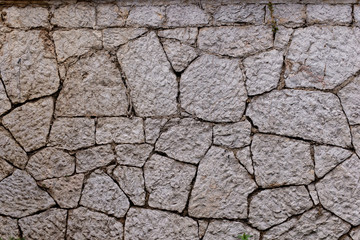 Texture of stone wall made of grey stones