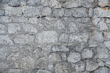 Texture of stone wall made of grey stones