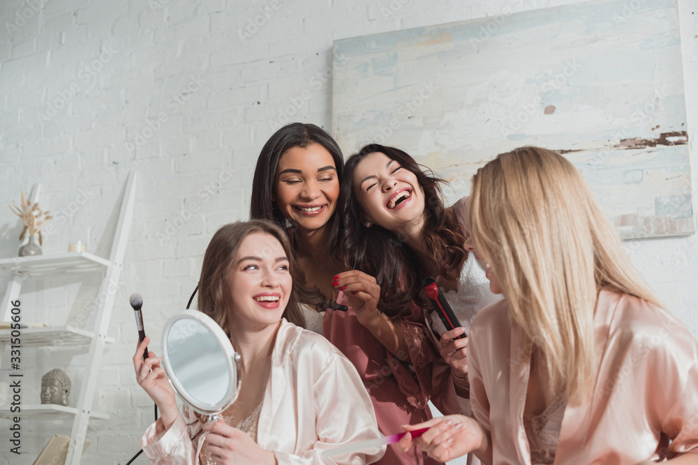 Wall mural Multiethnic women doing hairstyle, manicure and laughing at bachelorette party