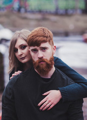 Image of young woman hugging handsome red head man outdoors