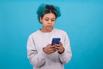 girl or young woman with colored hair and mobile phone isolated on blue background