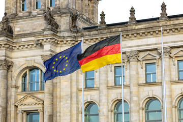 Flags of the European Union and Germany fluttering in the wind against the background of the building