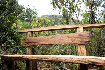 artesanal Wooden bench bank in middle of trekking path at andes mountain near to bogota city with nature and mountains at background in sunny day