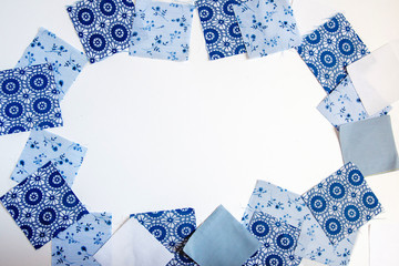 Square patches of blue printed fabric on a white background. Space for text
