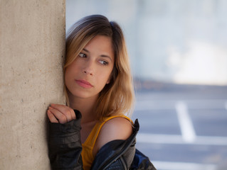 Woman in Leather Jacket Outside Next to Pillar