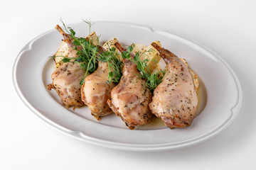 Baked tender juicy rabbit legs with celery. Banquet festive dishes. Gourmet restaurant menu. White background.