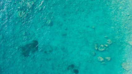 Aerial top down view photo of azure blue ocean waves showing beautiful bright and deep blue color from sea reef shallow water.
