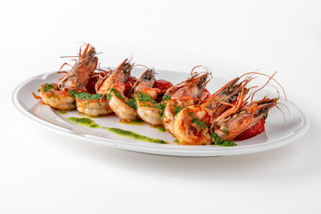 Luxurious seafood salad with grilled king prawns and baked cherry tomatoes. Banquet festive dishes. Gourmet restaurant menu. White background.