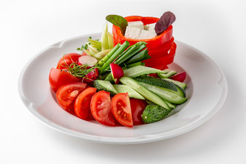 Snack from fresh vegetables and cheese. Tomatoes, cucumbers, peppers, onions. Banquet festive dishes. Gourmet restaurant menu. White background.