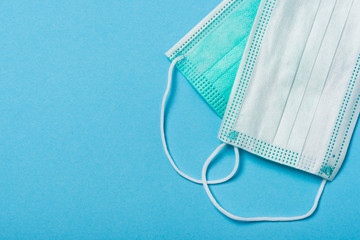 Surgical MEdical Mask on Blue Background. Coronavirus Pandemic Outbreak Copy Space Background